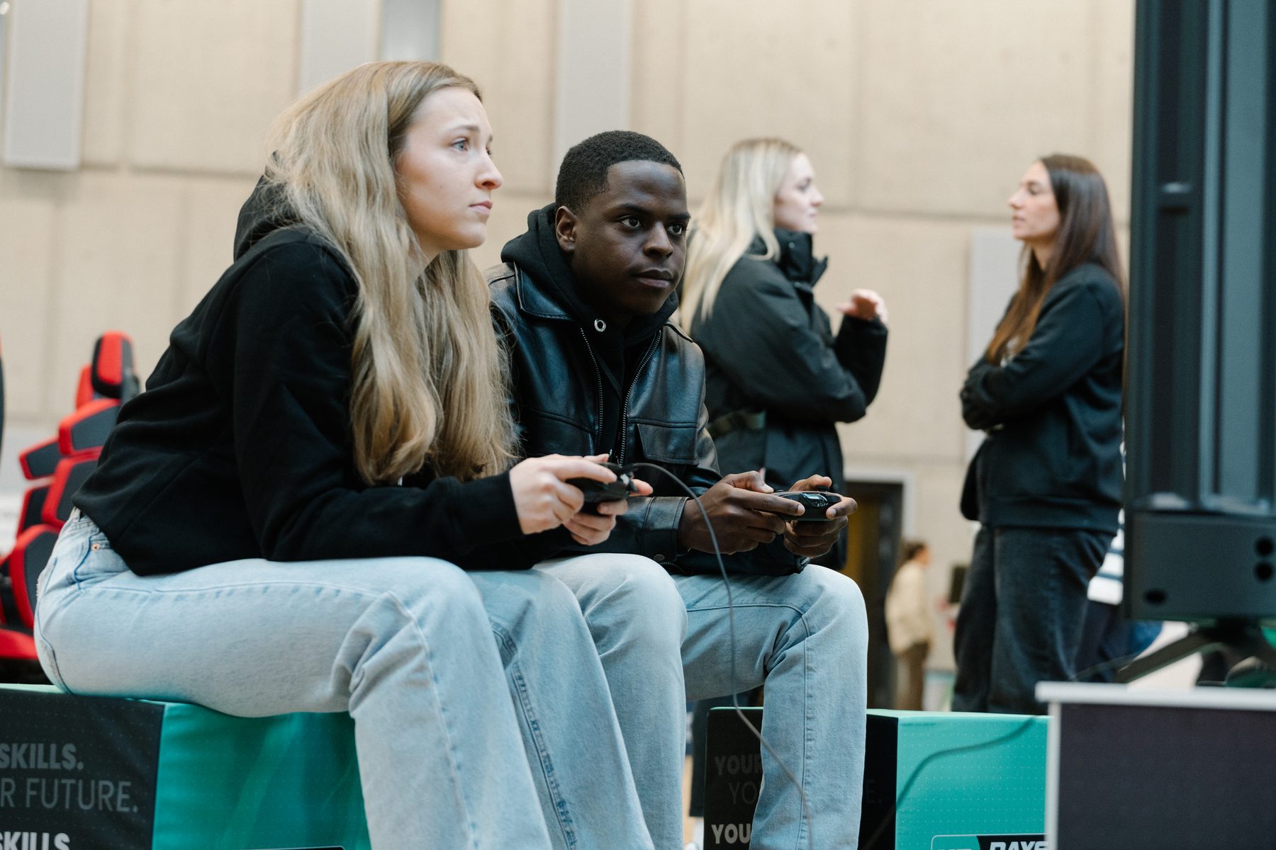 Zwei junge Menschen spielen an einer Konsole auf einer Messe – Gaming-Aktivierung von GG Manufaktur
